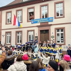 Man sieht den Karnevalverein tanzend vor dem Rathaus