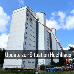 Auf dem Bild sieht man die kaputte Fassade des Hochhauses im Erloch sowie einen Kran.