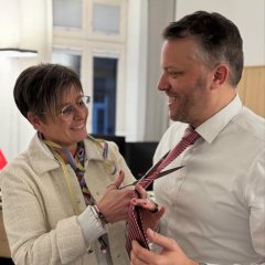 Man sieht wie Stefanie Jox die Krawatte des Bürgermeisters Dominik Stadler zerschneidet. 